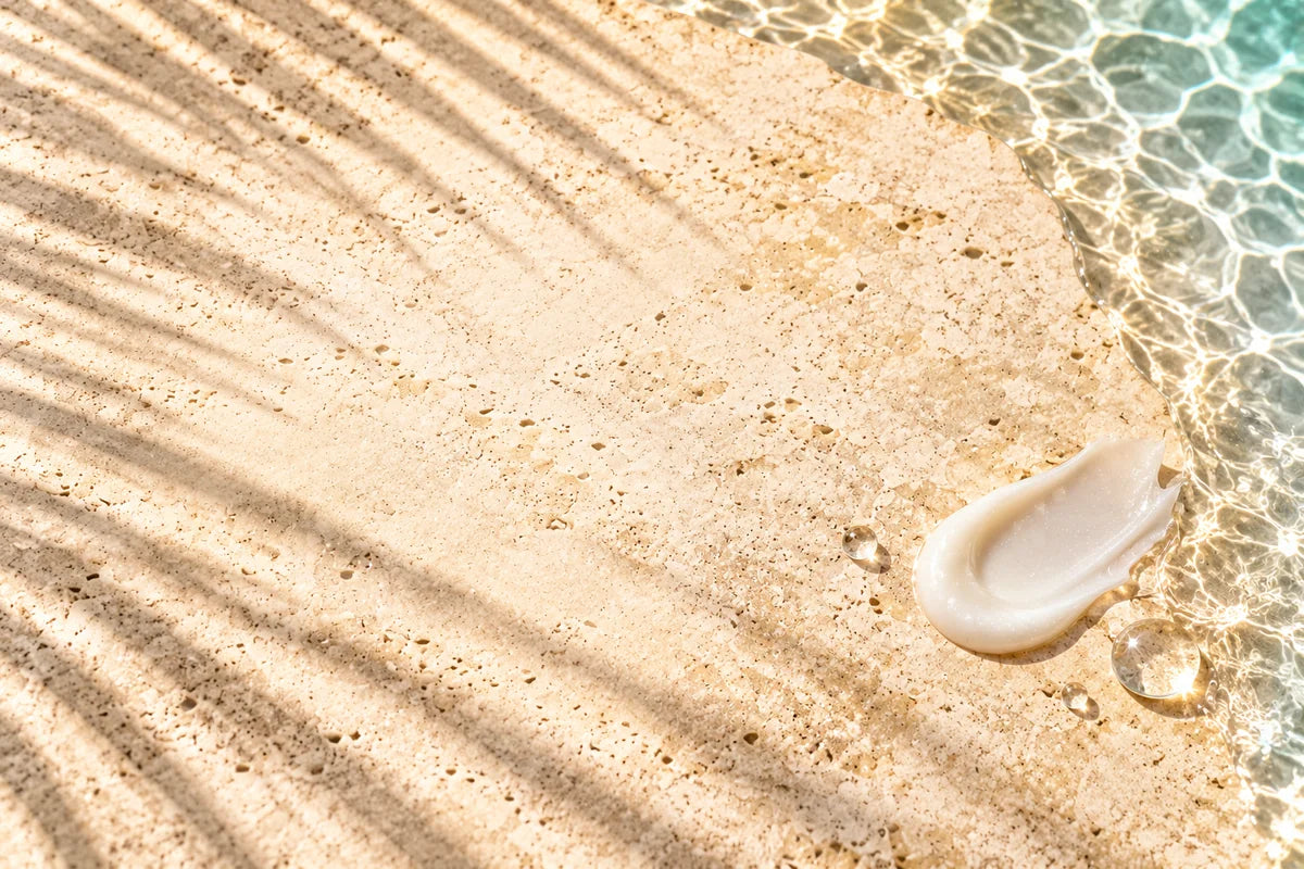 Cremige Balsam-Textur und Wassertropfen auf hellem Stein