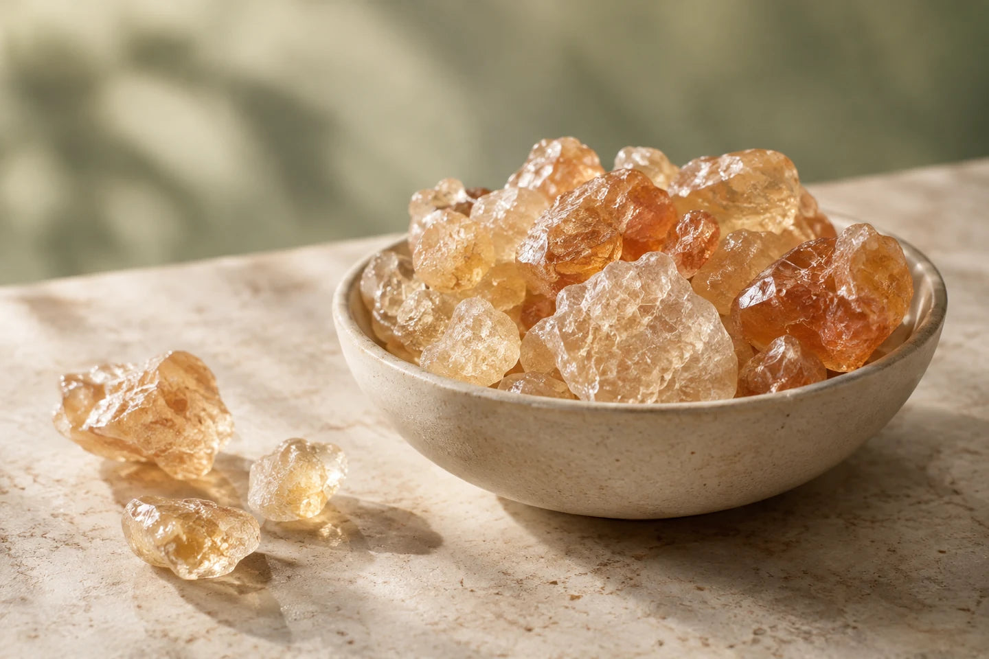Illustrative Darstellung: Gummi arabicum als bernsteinfarbene Stücke in einer Keramikschale