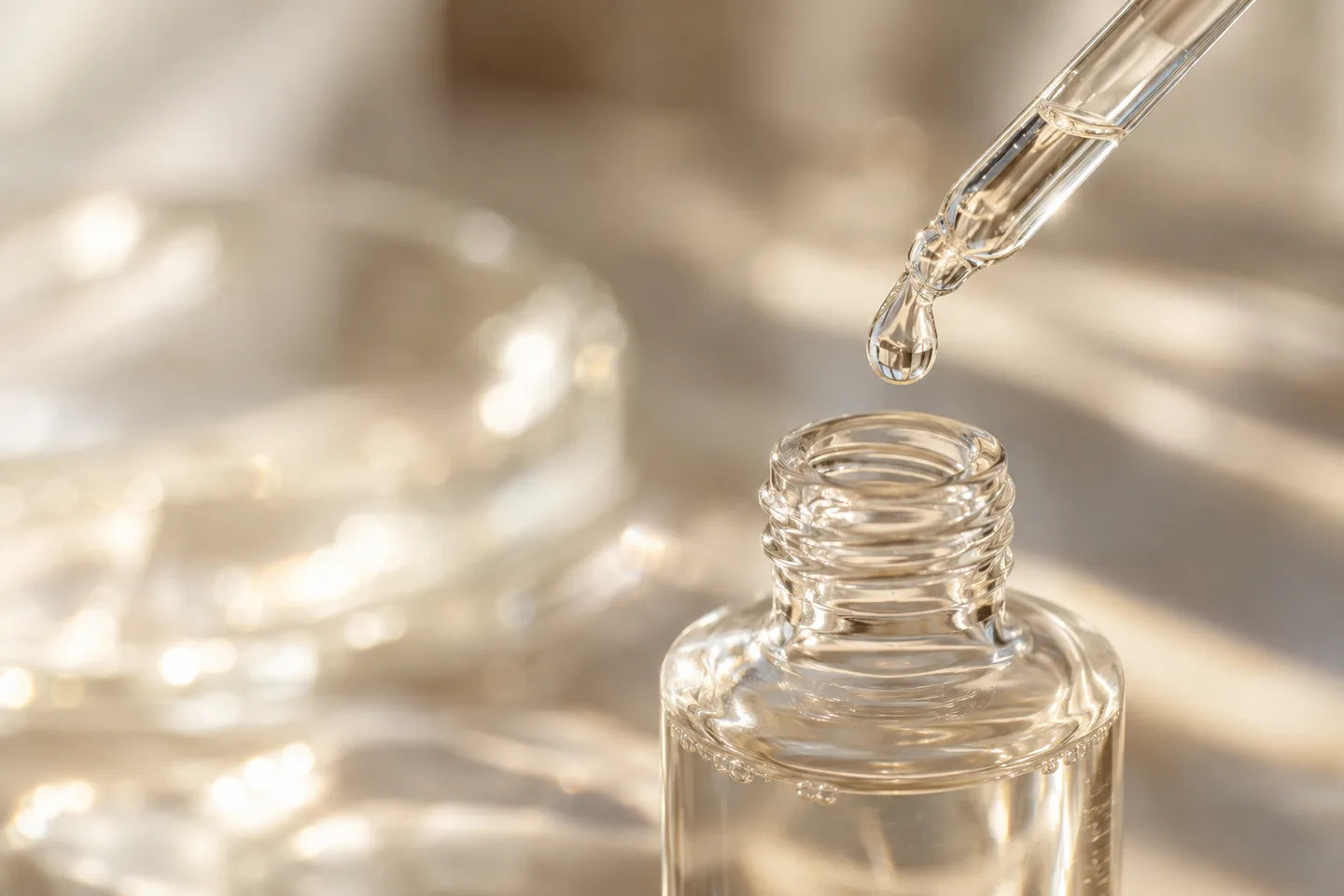 Illustrative Darstellung: Klare Capryl-/Caprinsäure-Triglyceride tropfen von einer Pipette